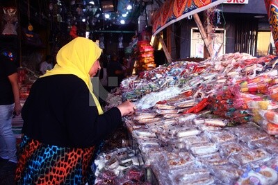 Woman puts the candies of the prophet Muhammad&#39;s birth on the box