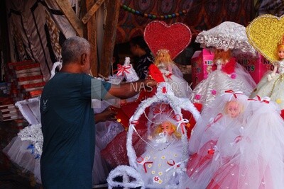 Close up of man standing selling the Mawlid dolls in the street, Egyptian Desserts of Prophet Muhammad&#39;s Birth Celebration