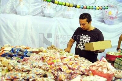 Man puts the candies of the prophet Muhammad&#39;s birth on the box
