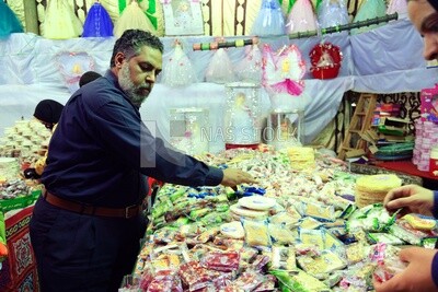 Man puts the candies of the prophet Muhammad&#39;s birth on the box