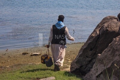 Shepherd carries jerry cans