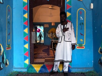 Nubian young man in traditional Nubian clothing inside a Nubian home, Aswan, Egypt