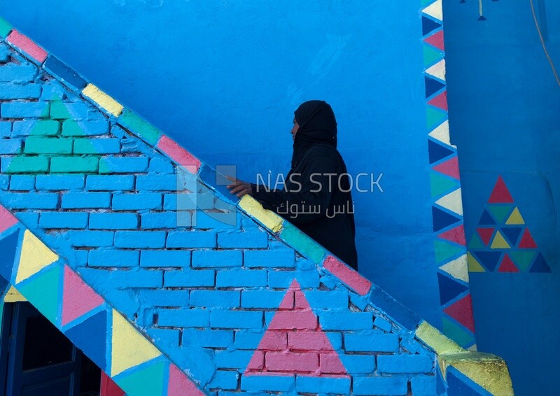 Woman climbs the stairs to her house, Nubia, Egypt