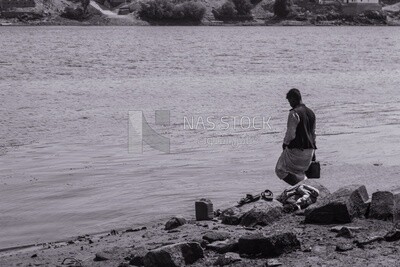 Shepherd filling jerry cans of water