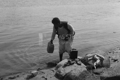 Shepherd filling jerry cans of water