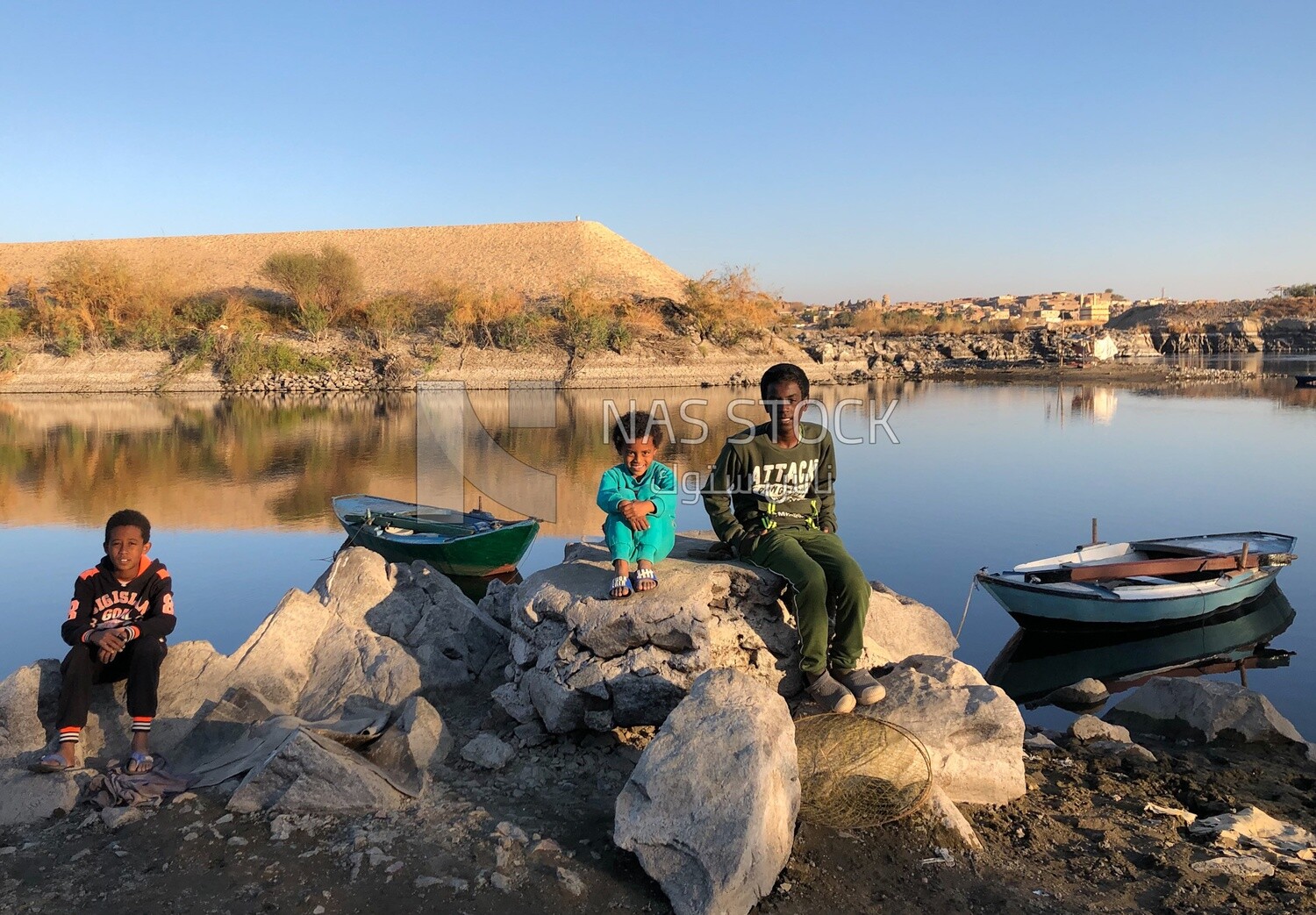 Nubian children sitting on the bank of the Nile ,Aswan, Egypt