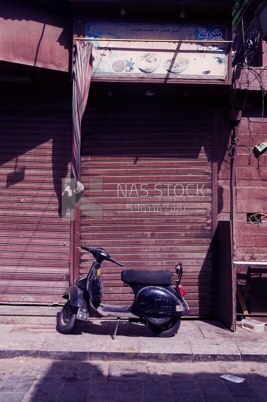 Motorcycle parked in front of a closed shop in a Cairo neighborhood