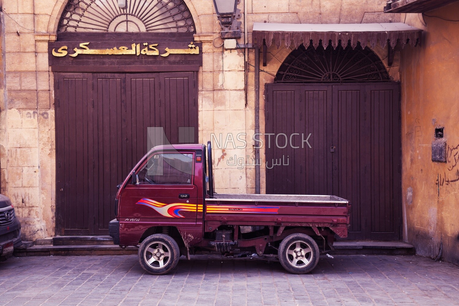 Suzuki pickup truck parked in front of one of the closed shops on Al Moez Street in Cairo