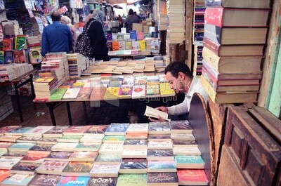 Man sitting reading a book in a bookstore