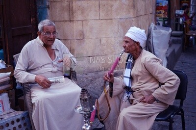رجلان بالغان يجلسان على المقهى احدهم يدخن الشيشة والاخر يحمل النقود , الصداقة , الحياة اليومية , مصر