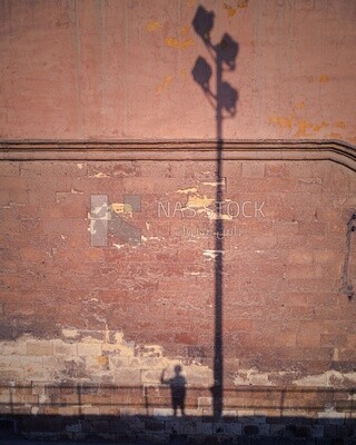 Shadow of a boy and a lamp on the wall