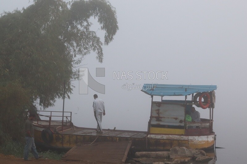 People waiting for the ferry boat on a foggy day, Sea transportation