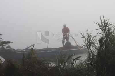 Man on a boat fishing in the middle of the sea during foggy weather, foggy weather