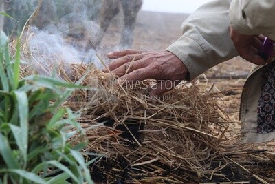 Farmer trying to burn the grass on the field