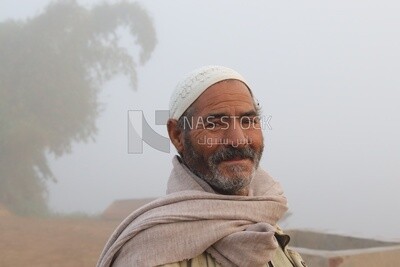 Close up of a man standing on a field on a foggy day