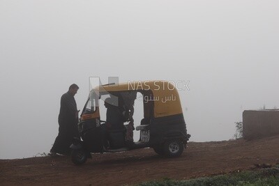 Tuk tuk on the road during foggy weather
