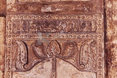 The wall of Ibn Tulun Mosque is Ornate engraved stone with floral patterns and calligraphy