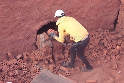 Worker transports bricks from the ground to the cart, brick industry
