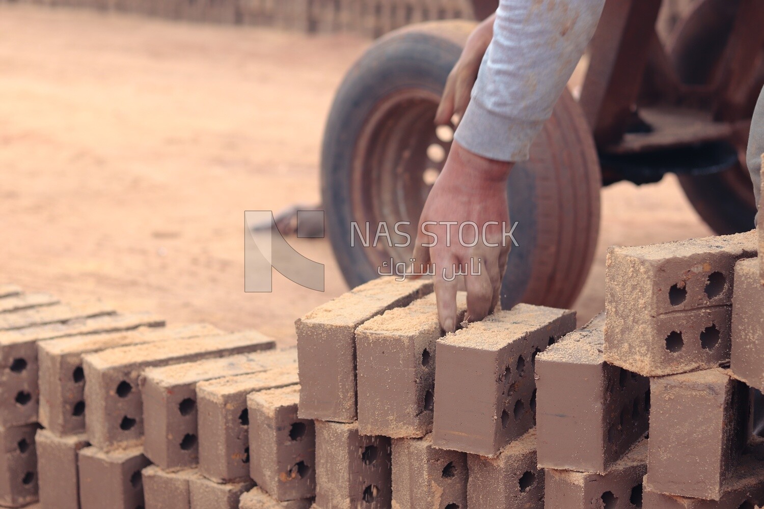 Worker transports bricks from the ground to the cart, brick industry