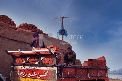 Worker transports bricks from the ground to the cart, brick industry