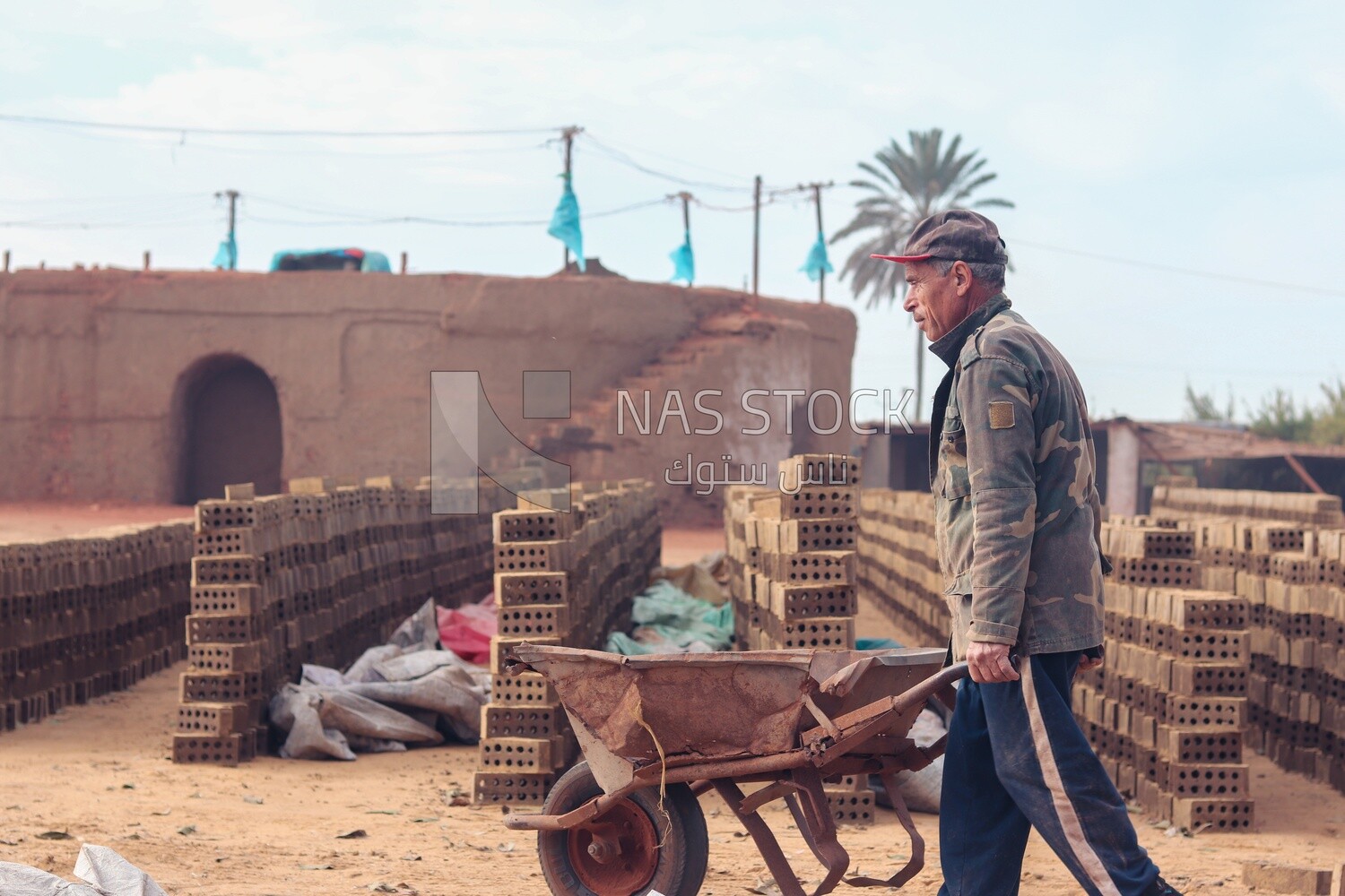 Worker pulling a cart in a brick factory, brick industry