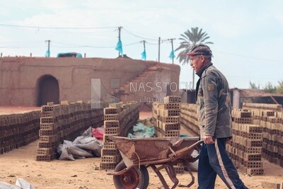 Worker pulling a cart in a brick factory, brick industry