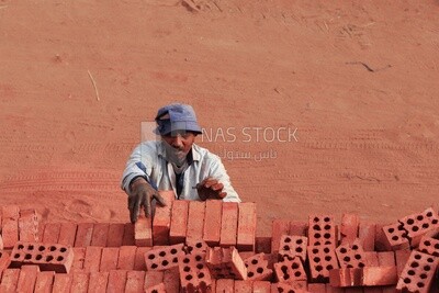 Worker transports bricks from the ground to the cart, brick industry