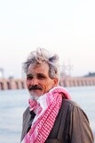 Close up of an old man sitting in front of the river