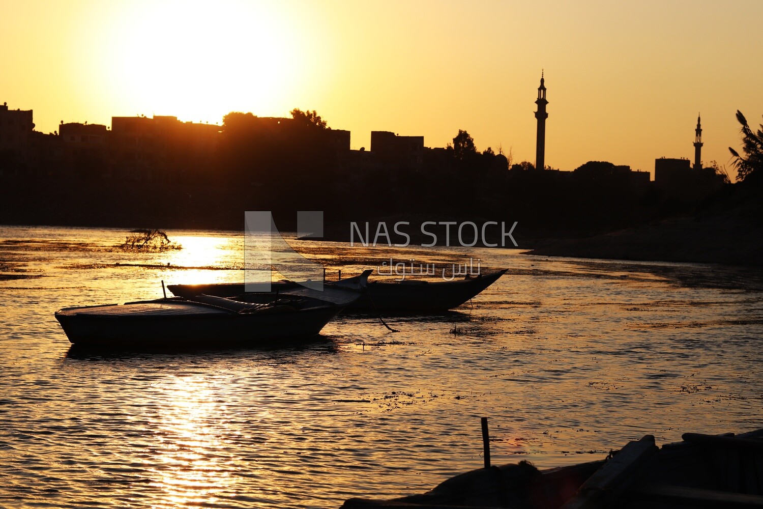 Boats sailing in the river during the sunset