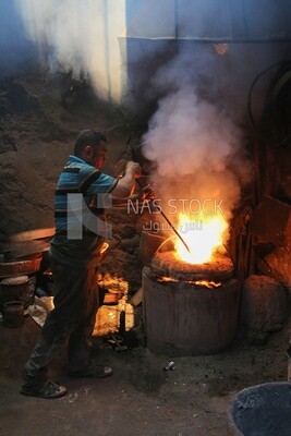 Blacksmith at work in his workshop by the fire, workshop, professional crafts