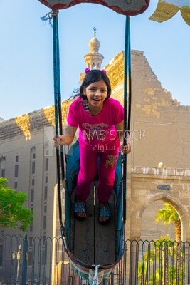 Girl playing on a swing in the street, Street, People