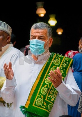 Man wearing white jilbab pray to the god