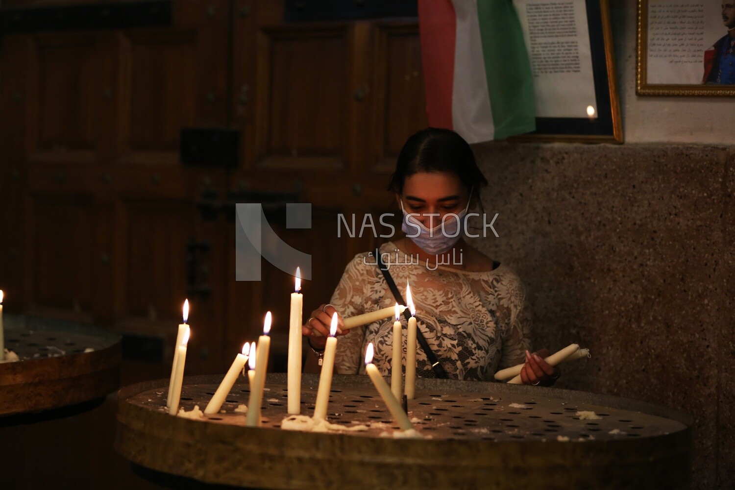 Girl lights candles in church
