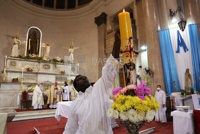 Church servant lights a candle to begin Easter celebrations