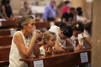 Mother with her children praying inside the church