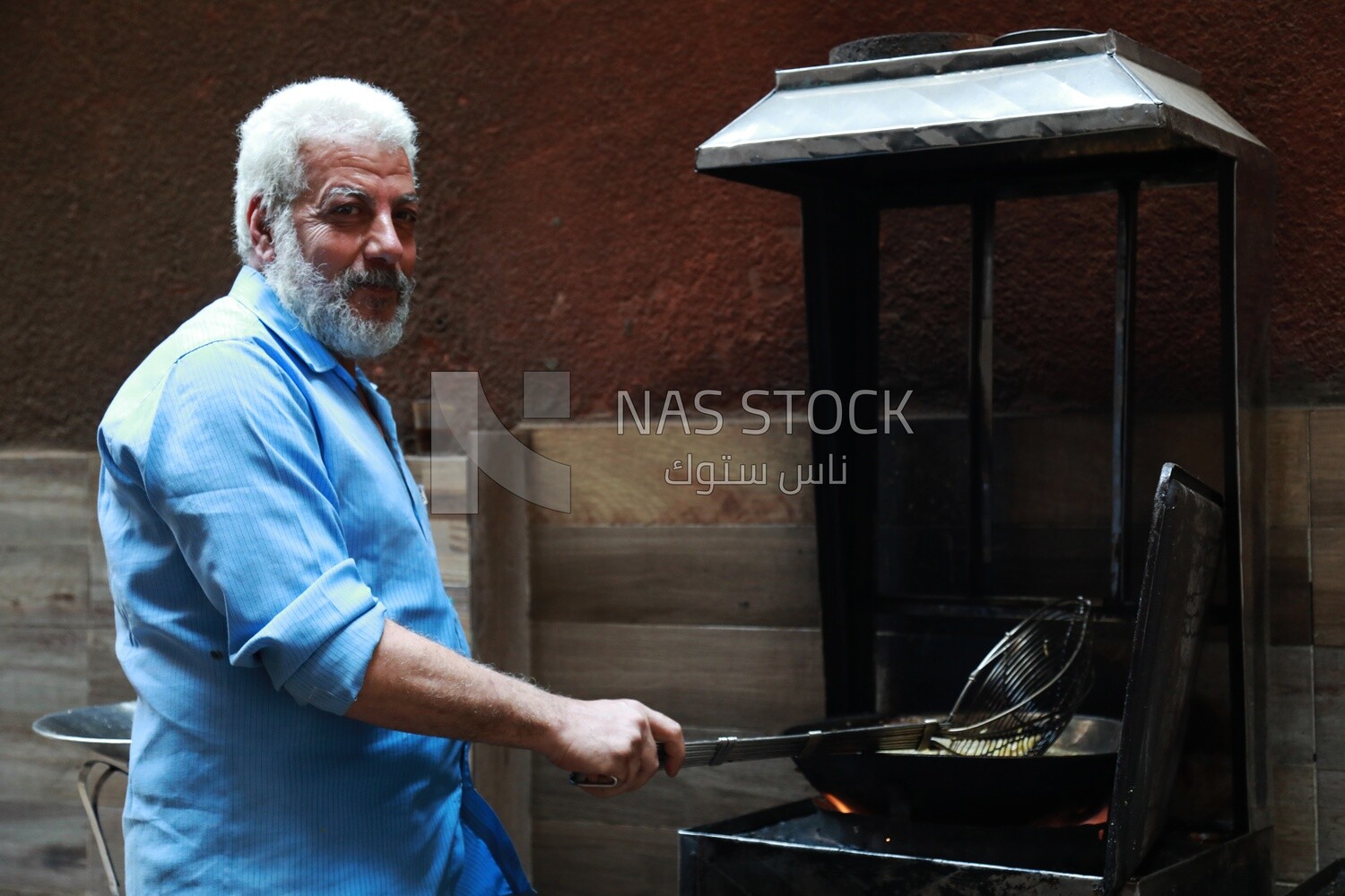Worker in a popular restaurant frying potatoes