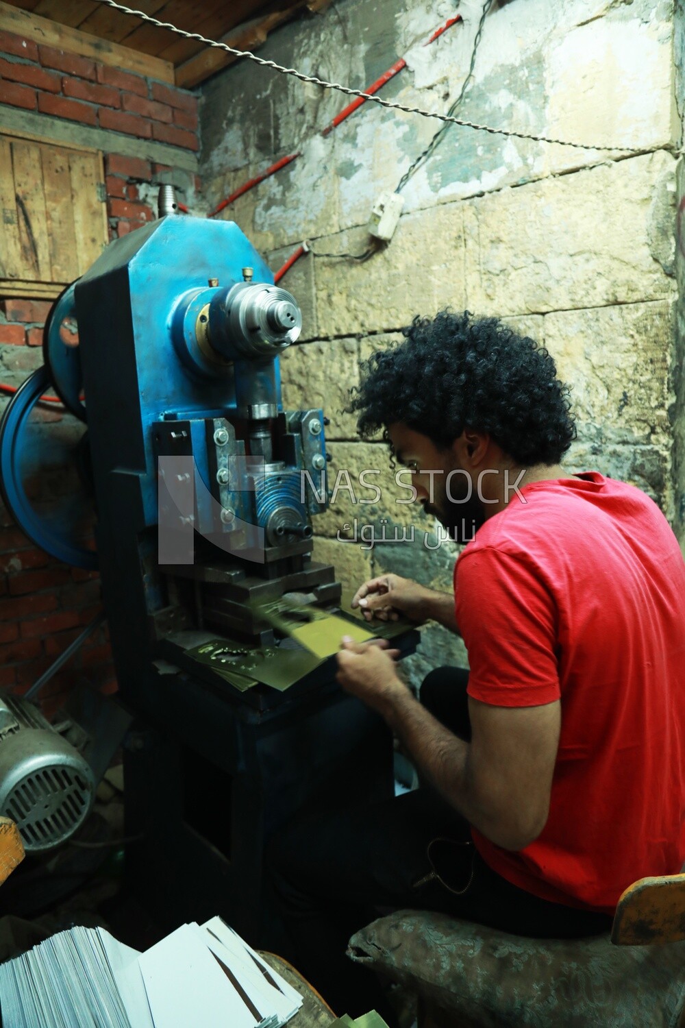 Young man works on a machine in a workshop