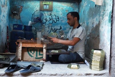 رجل حرفى يعمل فى ورشة لتشكيل الحديد , ورشة لتصنيع الفوانيس المعدنية , الحرف اليدوية