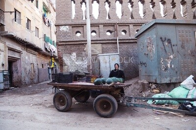سيدة تقف فى احد المناطق الشعبية بمصر مع عربة محملة بالبطيخ لبيعه , الباعة الجائلين