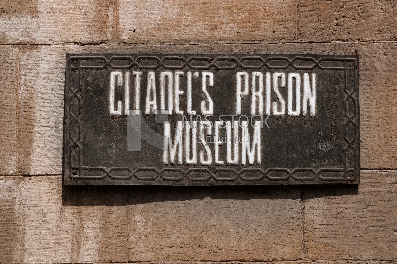 Hanging sign with the name of the citadel&#39;s prison museum on the wall