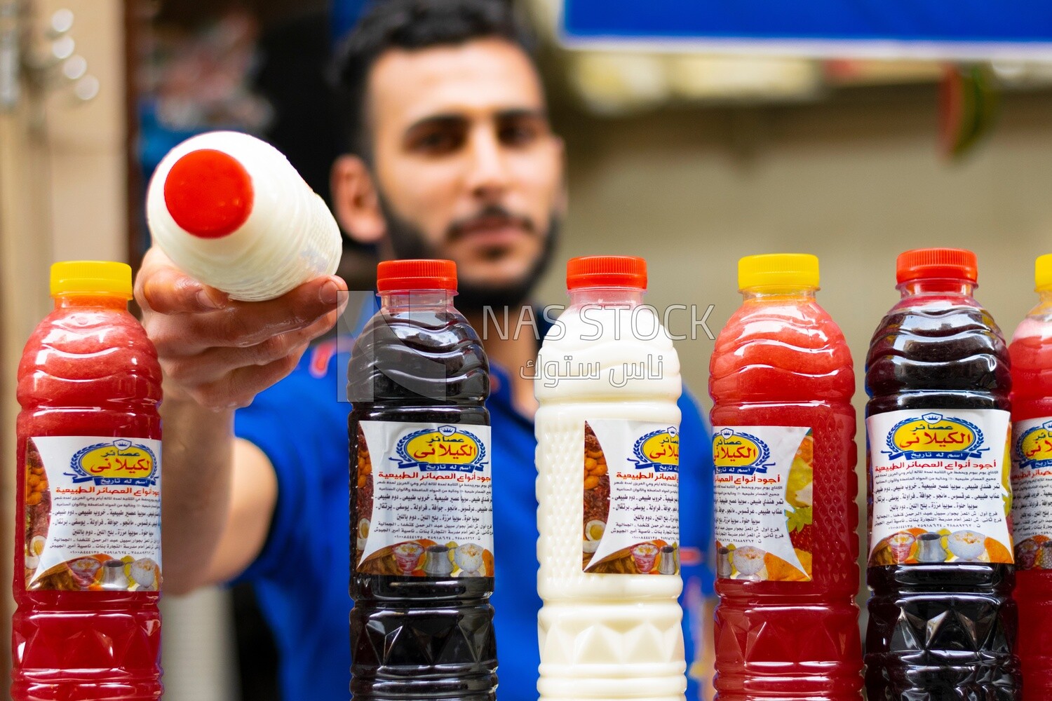 Man standing in a juice cart selling juice to people on the street