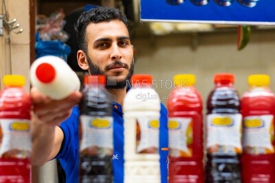 رجل يقف في عربة عصير ويبيع العصير للناس في الشارع