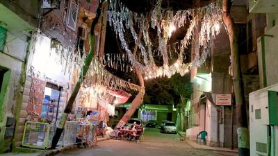 Women sitting in the street watching the television, street, ramadan decorations