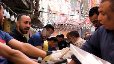 Men putting the food on the plates to share the iftar together in the street, Ramadan Kareem, preparing their iftar