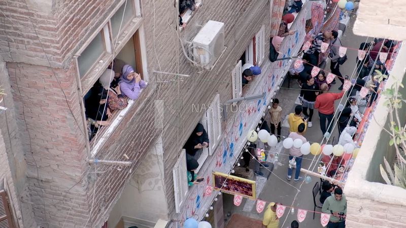 Women standing on the balcony watching the preparing of the iftar, Ramadan Kareem, preparing their iftar