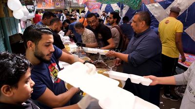الرجال يضعون الطعام فى الصحون لتقاسم الإفطار معا في الشارع ، رمضان كريم ، لتحضير الإفطار.
