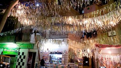Women sitting in the street watching the television, street, ramadan decorations