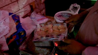 Man puts Kahk on the balance, bakery store, eid