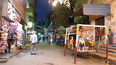 Boy sitting on the swing in the street, Ramadan nights