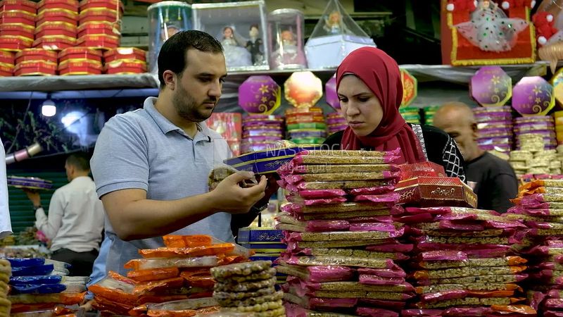 Man helps a woman buy the candies of the prophet Muhammad&#39;s birth on the street